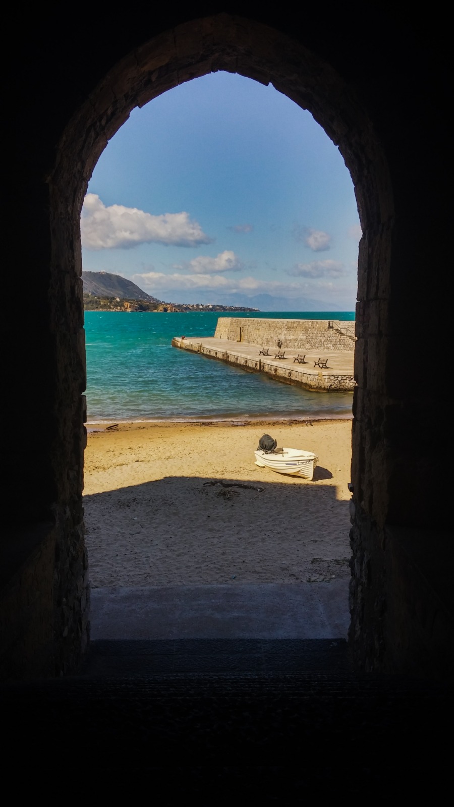 Sea view through the historic Porta Pescara archway in Cefalù, Sicily